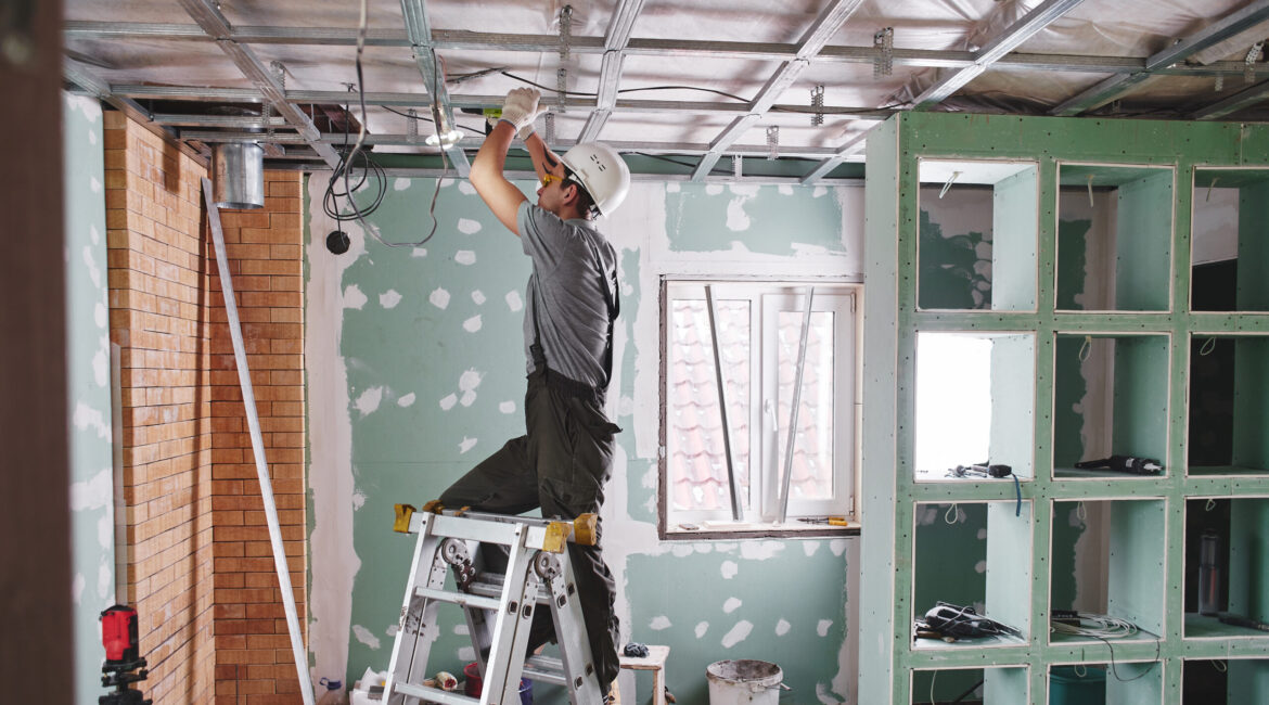 Room repair. Interior finish. young builder makes a plasterboard ceiling standing on a stepladder - Maydek İnşaat İzmir