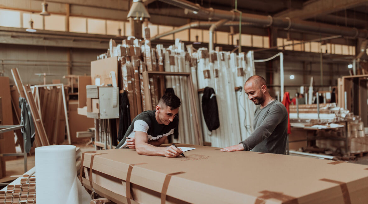 Two diligent workers collaboratively prepare the final wooden product for plasma treatment ensuring impeccable quality and craftsmanship as they ready it for the global market exemplifying precision and dedication in the woodworking industry - Maydek İnşaat İzmir